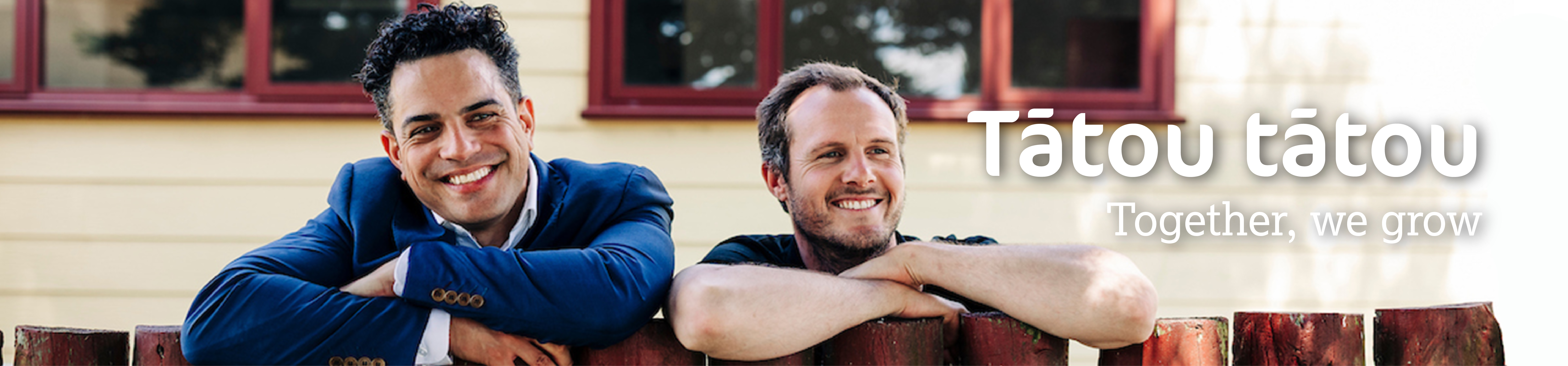 Ricky and Raymond peering over the fence with smiles on their faces